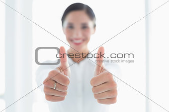 Blurred business woman gesturing thumbs up