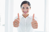 Smiling business woman gesturing thumbs up