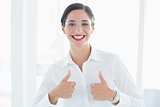 Smiling business woman gesturing thumbs up