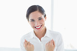 Excited young business woman clenched fists