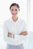 Smiling business woman standing with arms crossed