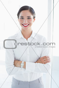 Smiling business woman standing with arms crossed