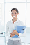 Smiling business woman with folder in office