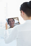 Business woman looking at her reflection in tablet PC