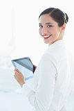 Smiling business woman with tablet PC in office
