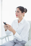 Business woman with mobile phone looking away