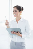 Smiling young business woman with clipboard and pen