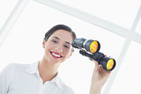 Smiling business woman  with binoculars in office