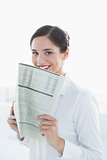 Smiling business woman holding newspaper