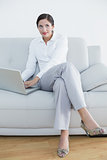 Well dressed woman using laptop while looking up