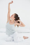 Sleepy woman stretching her arms up