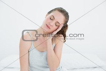 Sleepy woman sitting in bed