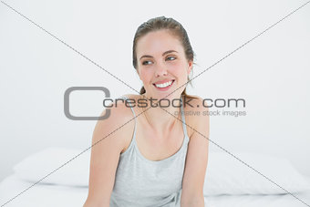 Happy woman looking away in bed