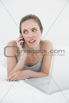 Casual woman using cellphone and laptop