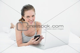 Portrait of a relaxed casual woman using cellphone and laptop