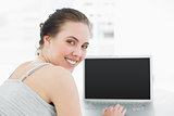 Close up portrait of a smiling casual woman with laptop