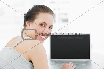 Close up portrait of a smiling casual woman with laptop