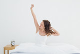 Sleepy woman stretching her arms in bed