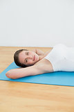 Young woman resting on exercise mat