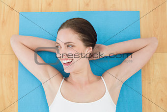 Cheerful woman lying on exercise mat