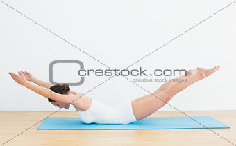 Side view of a woman exercising on mat