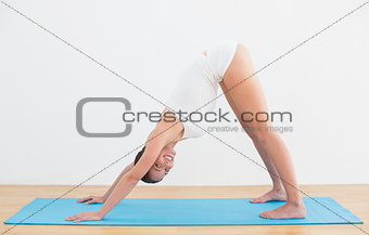 Side view of a smiling woman exercising on mat