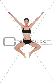 Sporty young woman jumping isolated on white background