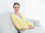Relaxed young woman sitting on sofa at home