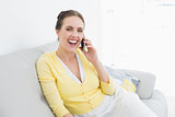 Cheerful woman using mobile phone at home
