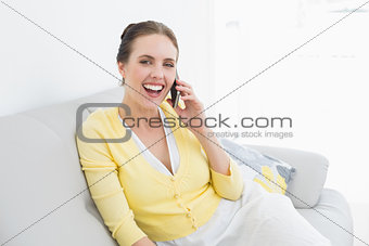 Cheerful woman using mobile phone at home