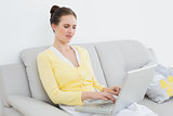 Woman using laptop on sofa at home