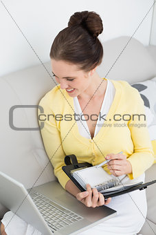Woman using personal organizer and laptop