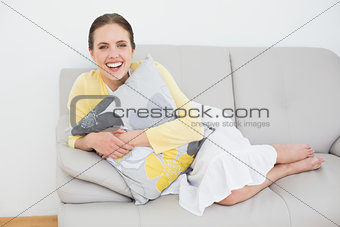 Cheerful young woman relaxing on sofa
