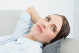 Close up of a thoughtful woman relaxing on sofa