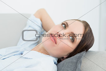 Close up of a thoughtful woman relaxing on sofa