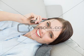 Smiling woman using mobile phone at home