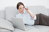 Portrait of a smartly dressed woman using laptop on sofa