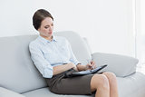 Well dressed woman using personal organizer at home