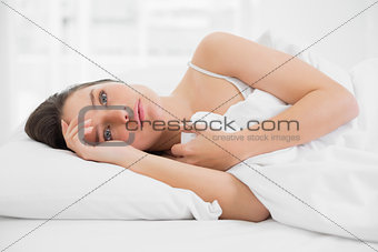 Beautiful woman looking away in bed