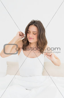 Woman waking up in bed with eyes closed