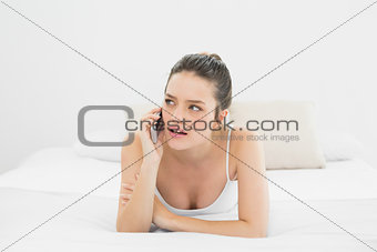 Casual woman using mobile phone in bed