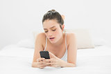 Woman looking at mobile phone in bed