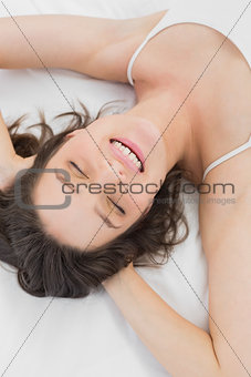 Pretty smiling young sleeping in bed