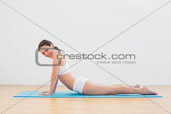 Portrait of woman doing cobra pose on exercise mat