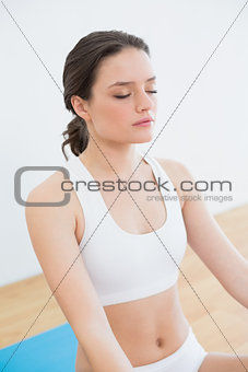 Fit woman with eyes closed at fitness studio