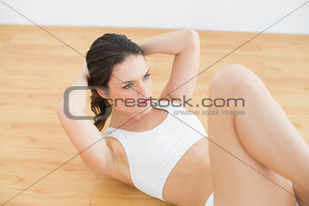 Sporty fit young woman doing sit ups in fitness studio
