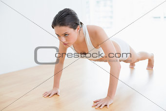 Full length of a sporty young woman doing push ups