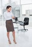 Elegant young businesswoman with clipboard in office