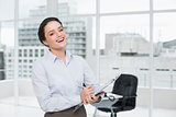 Cheerful elegant businesswoman with clipboard in office