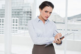 Elegant young businesswoman with clipboard in office